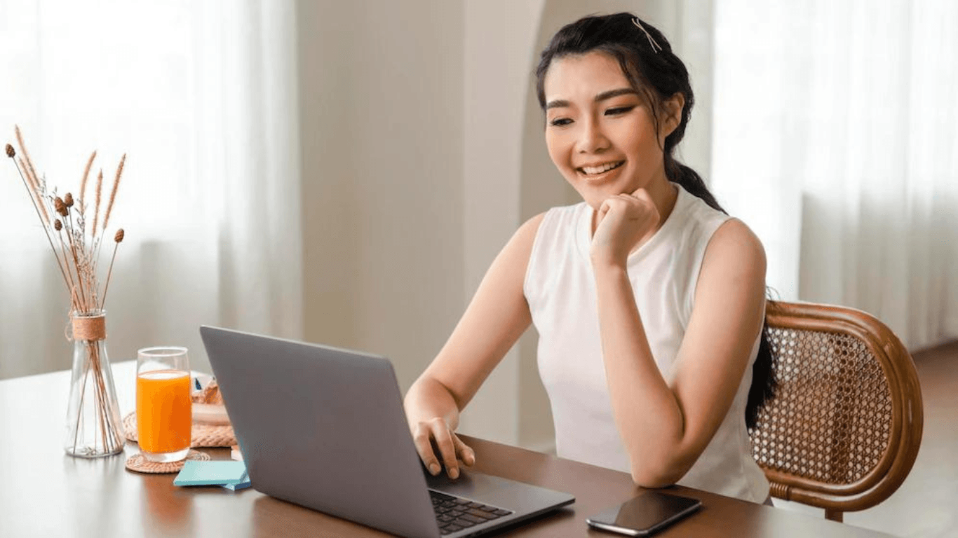 A female online retailer checking something on her laptop while smiling